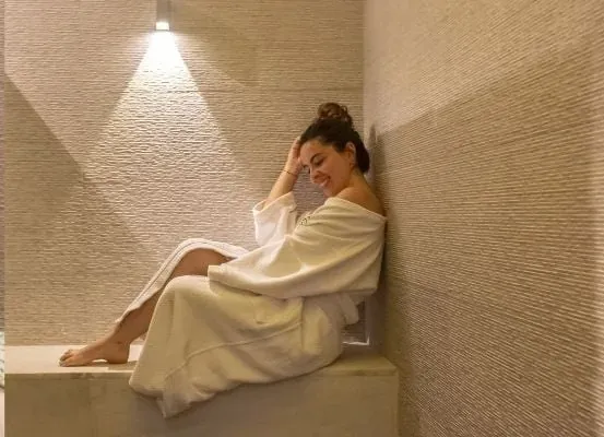 Relax at The Fives Corpo spa in a white robe.