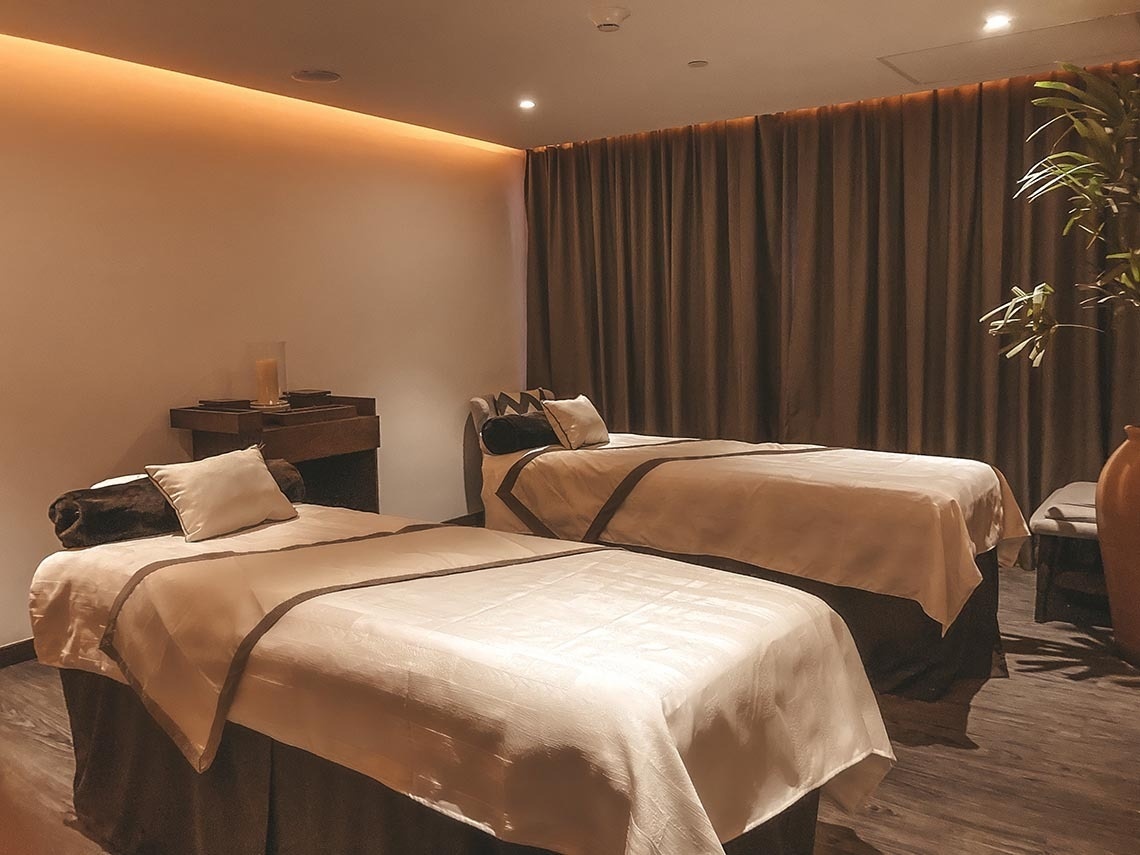 Salón de masajes doble con dos camas preparadas en The Fives Oceanfront Riviera Maya. Relájese en nuestro spa.