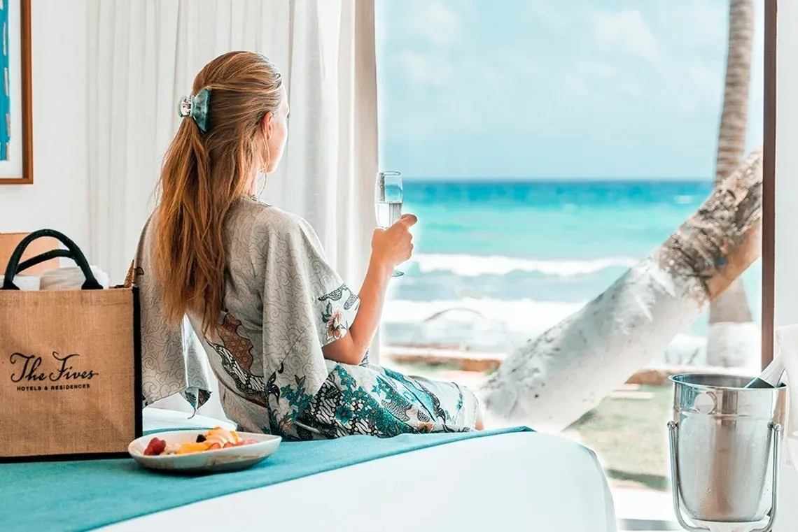 Woman with wine glass enjoying ocean view at The Fives Corpo.