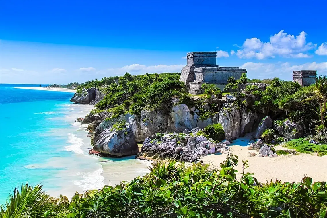 Mayan ruins overlooking turquoise sea at Tulum. An unforgettable view with The Fives Corpo.