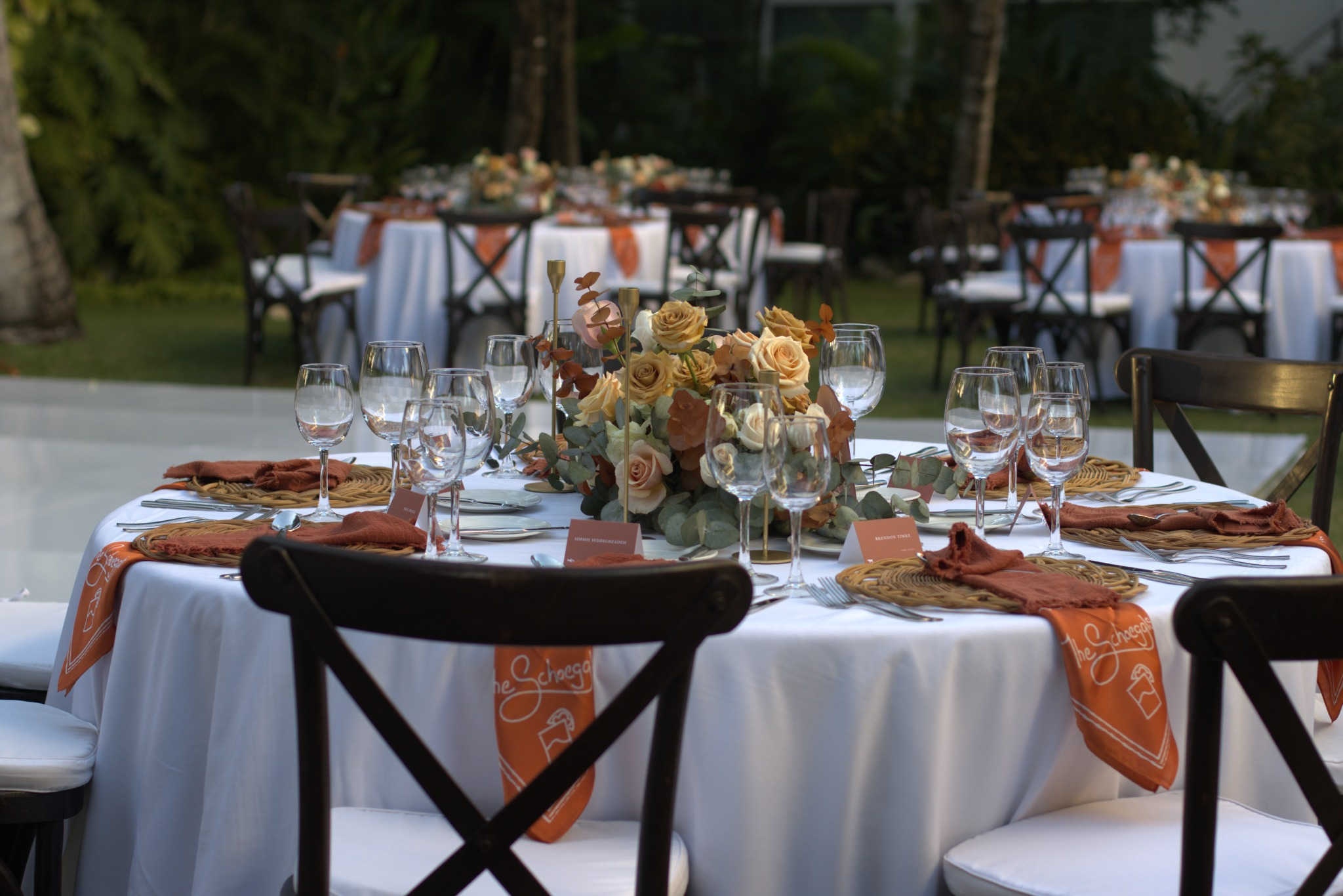 Outdoor garden wedding setup with elegant tables and tropical greenery