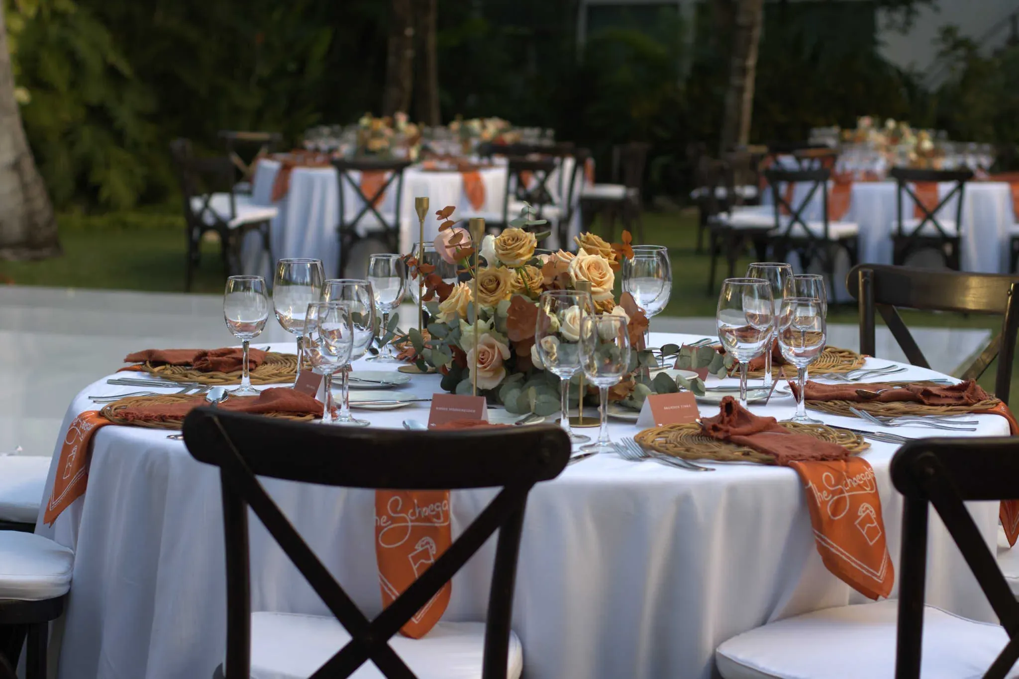 Montaje de boda al aire libre en jardín con mesas elegantes y vegetación tropical
