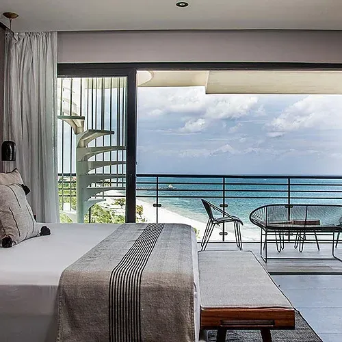 Luxury hotel room at The Fives with balcony overlooking the Caribbean Sea.
