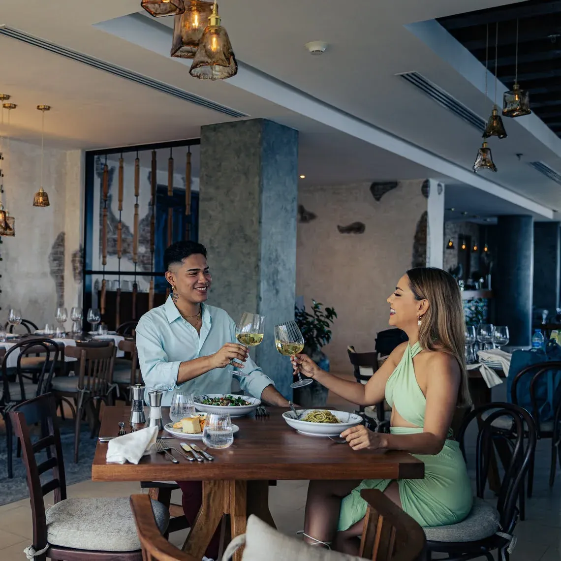 Pareja brindando con vino en The Fives Corpo. Cena romántica.