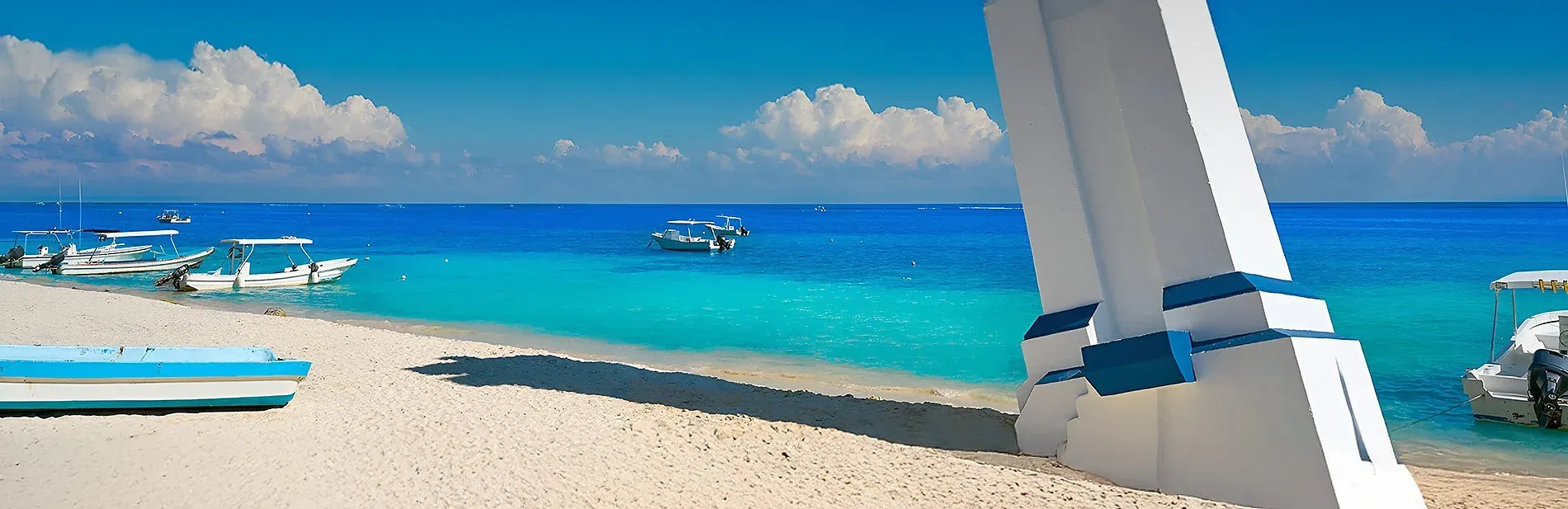Turquoise waters and white sand beach with boats at The Fives Hotels, Riviera Maya | Mexico official website.