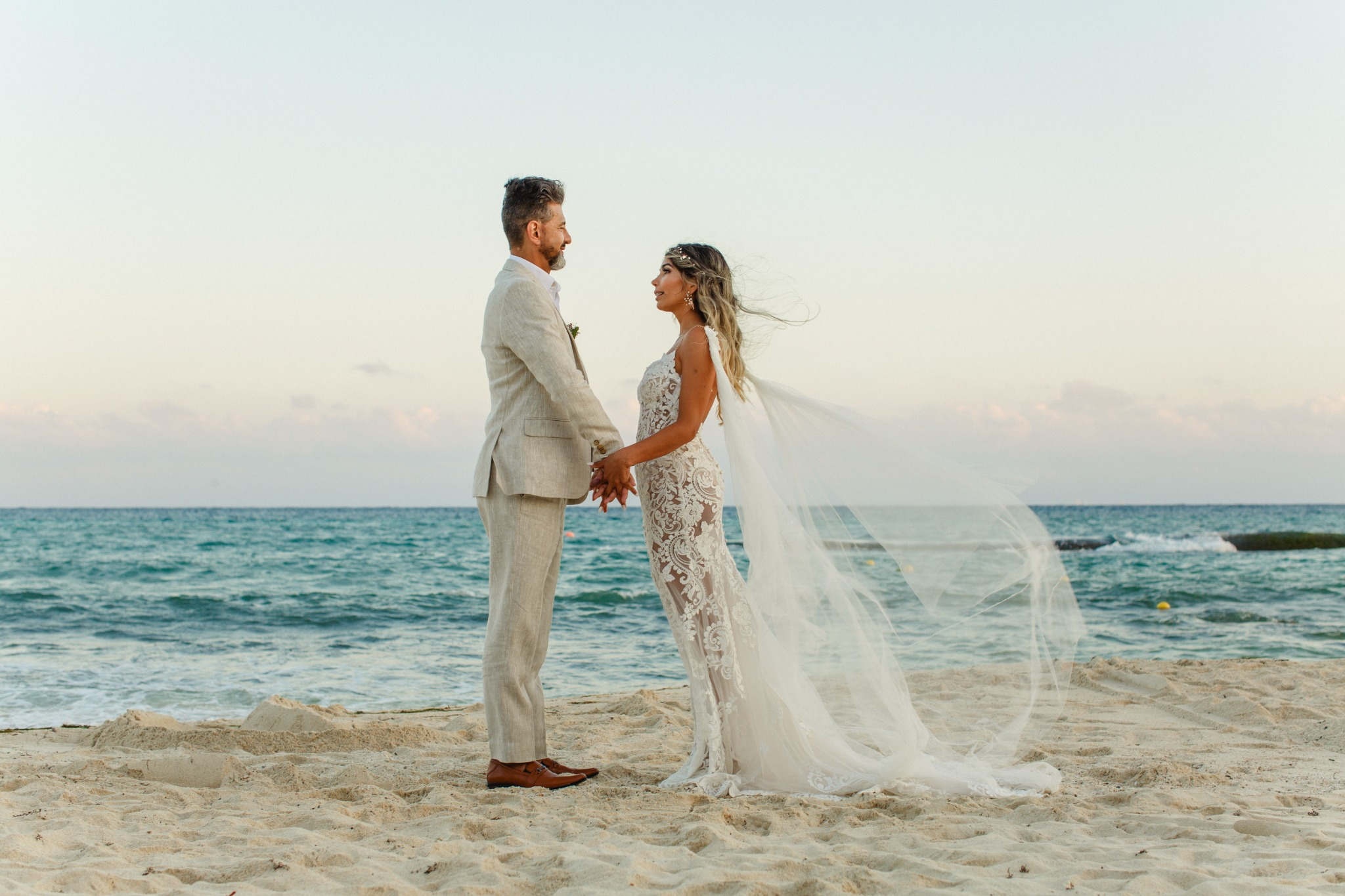 Bride and groom walking on the beach during a destination wedding in Riviera Maya