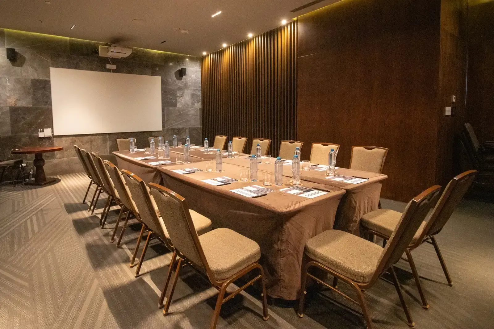 The Fives Corpo: Conference room with U-shaped table, chairs, projector, and whiteboard.