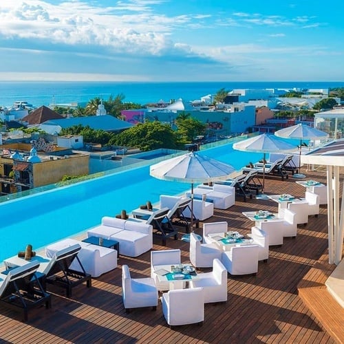 a large swimming pool with tables and chairs surrounding it