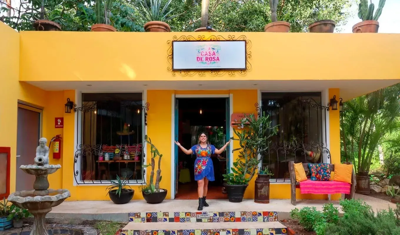 Casa de Rosa: Live the Mexican Tradition. Vibrant yellow facade with colorful decor.
