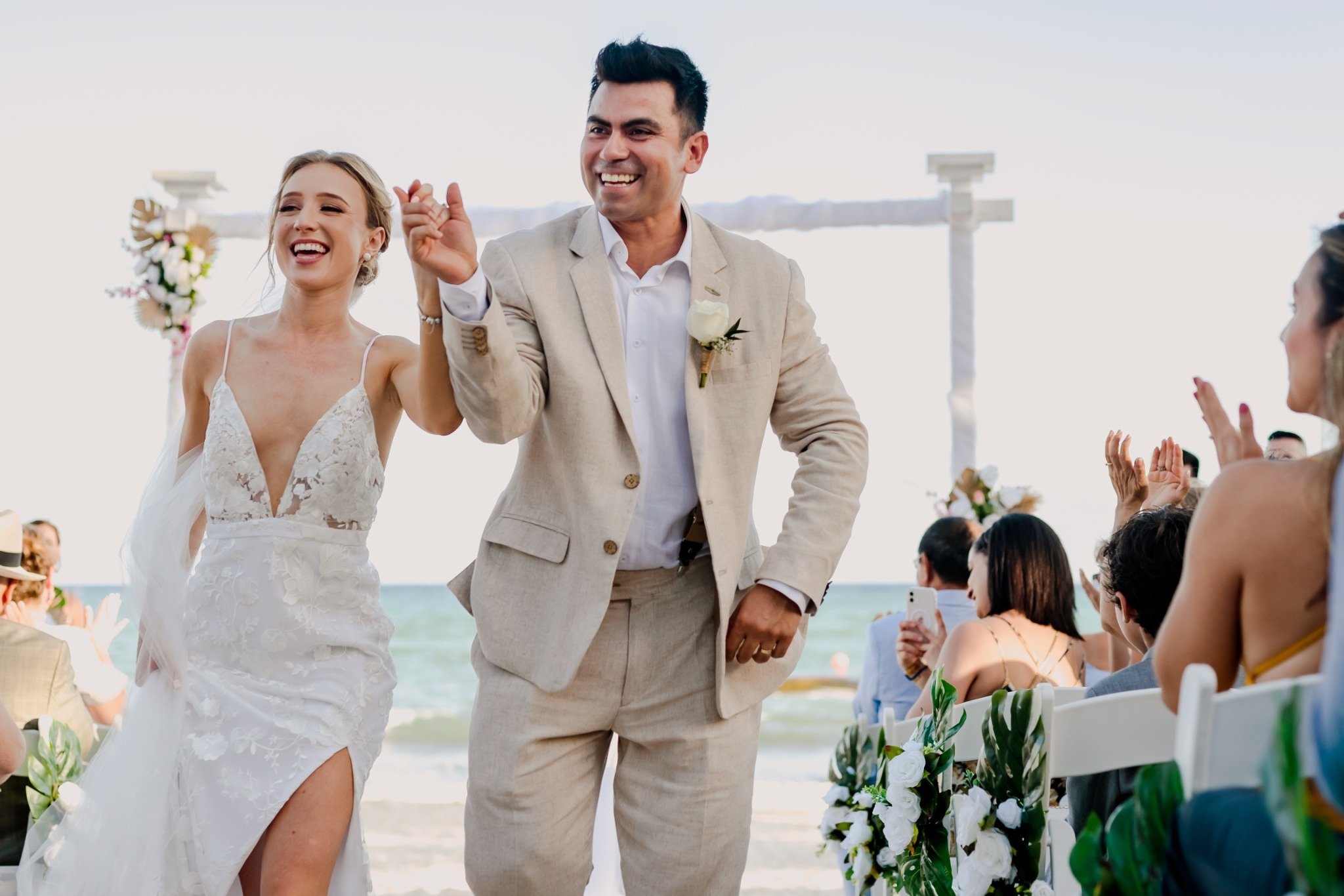 Happy bride and groom celebrating their beach wedding The Fives Corpo reception with guests.
