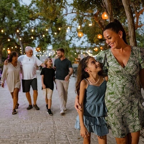 a woman in a green dress is walking with her family