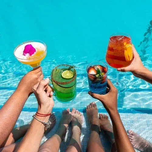 People toasting cocktails in The Fives Corpo pool.
