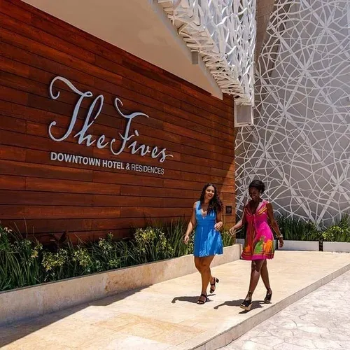 Two women walk past The Fives Downtown Hotel & Residences entrance.