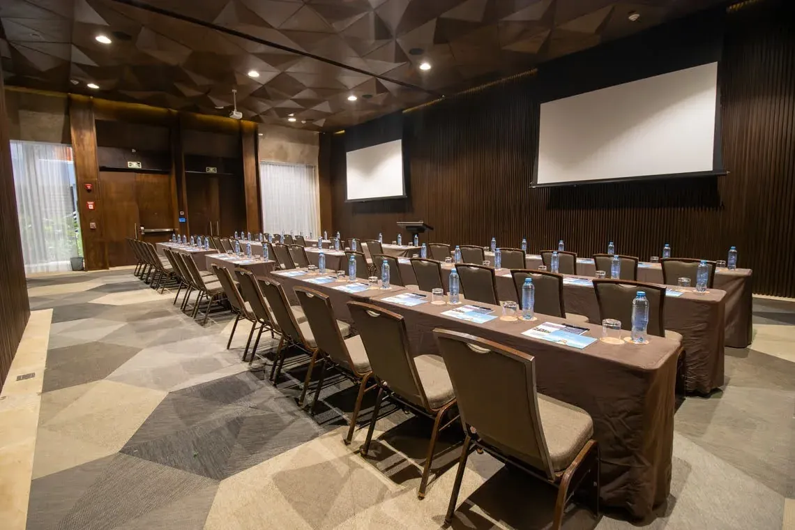 The Fives Corpo meeting room: tables, chairs, and screens for corporate events.