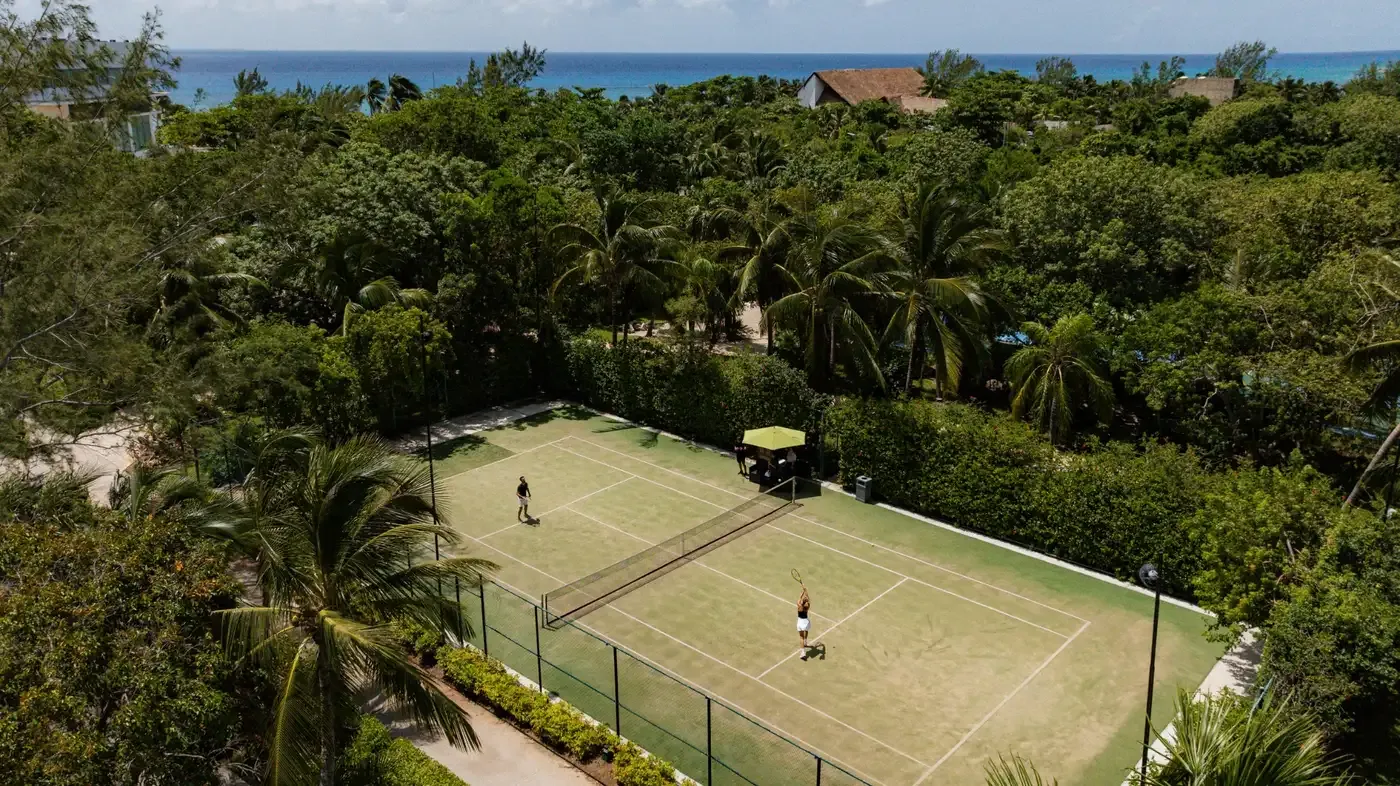 Tennis court at tropical resort, ocean view and lush greenery, The Fives Corpo.