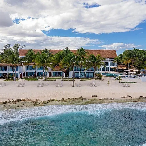 The Fives Corpo: Beachfront hotel with palms, pool, and Caribbean Sea views.