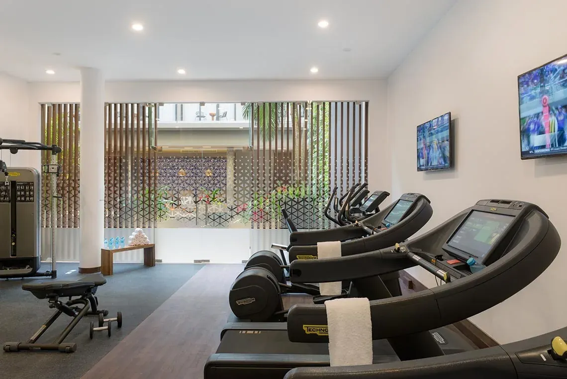 Modern gym at The Fives Downtown Hotel with treadmills and elliptical machines.