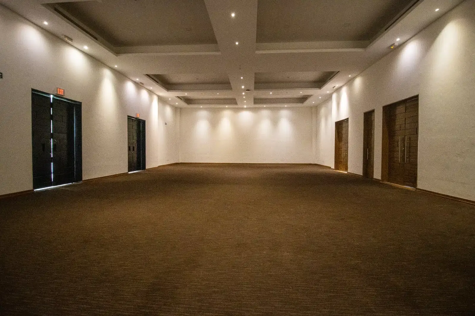 Spacious ballroom with plush carpet and modern lighting, ideal for your next The Fives Corpo event.