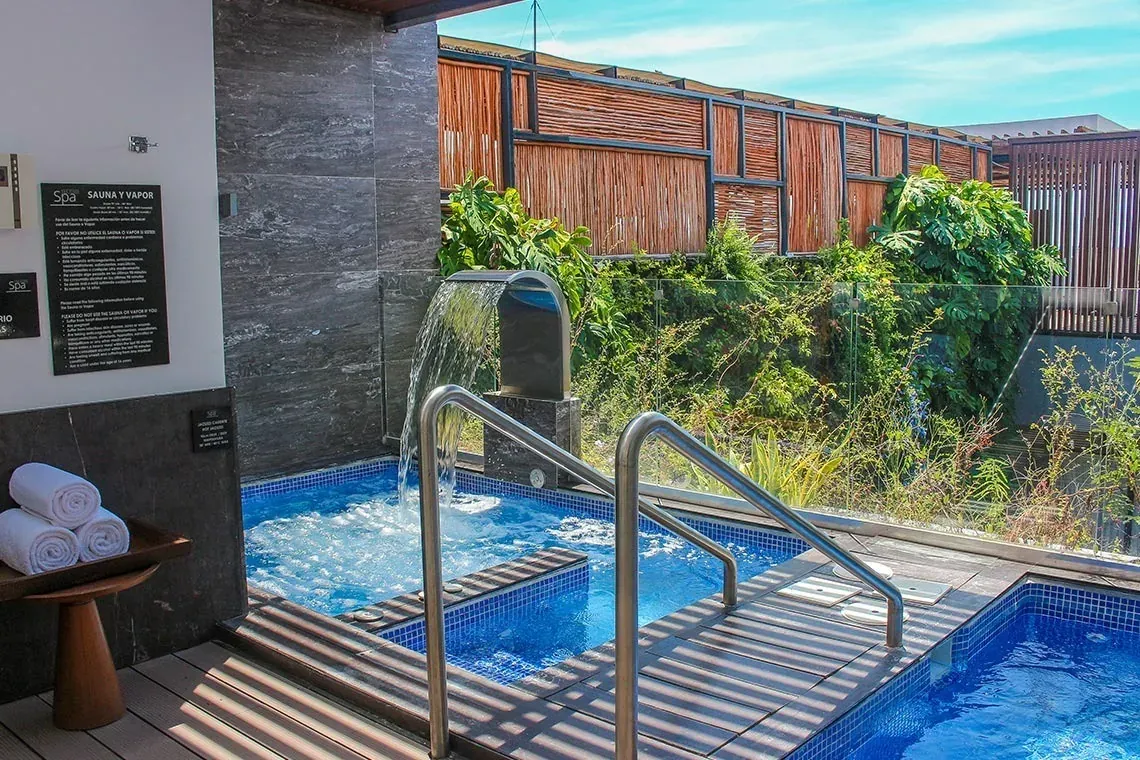 Jacuzzi exterior y cascada en The Fives Corpo. Relájese en un oasis de spa.