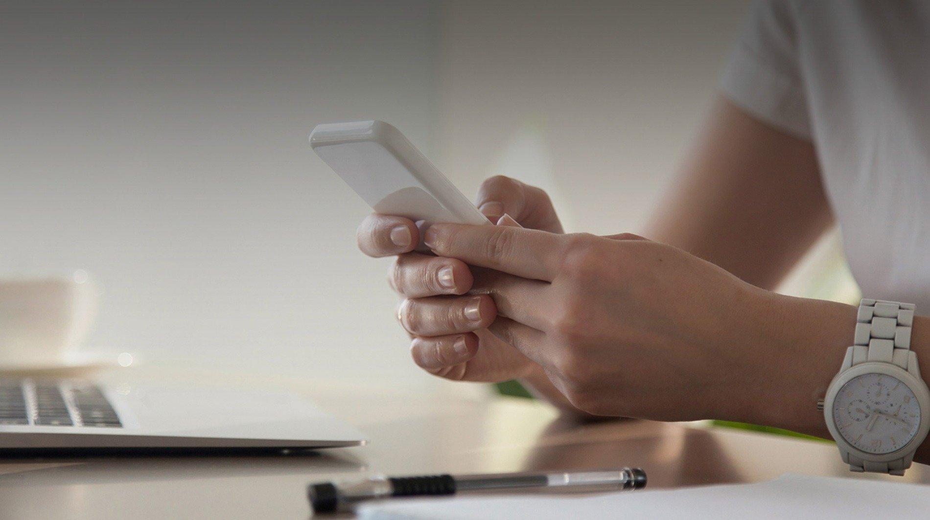 a woman wearing a watch is using a cell phone