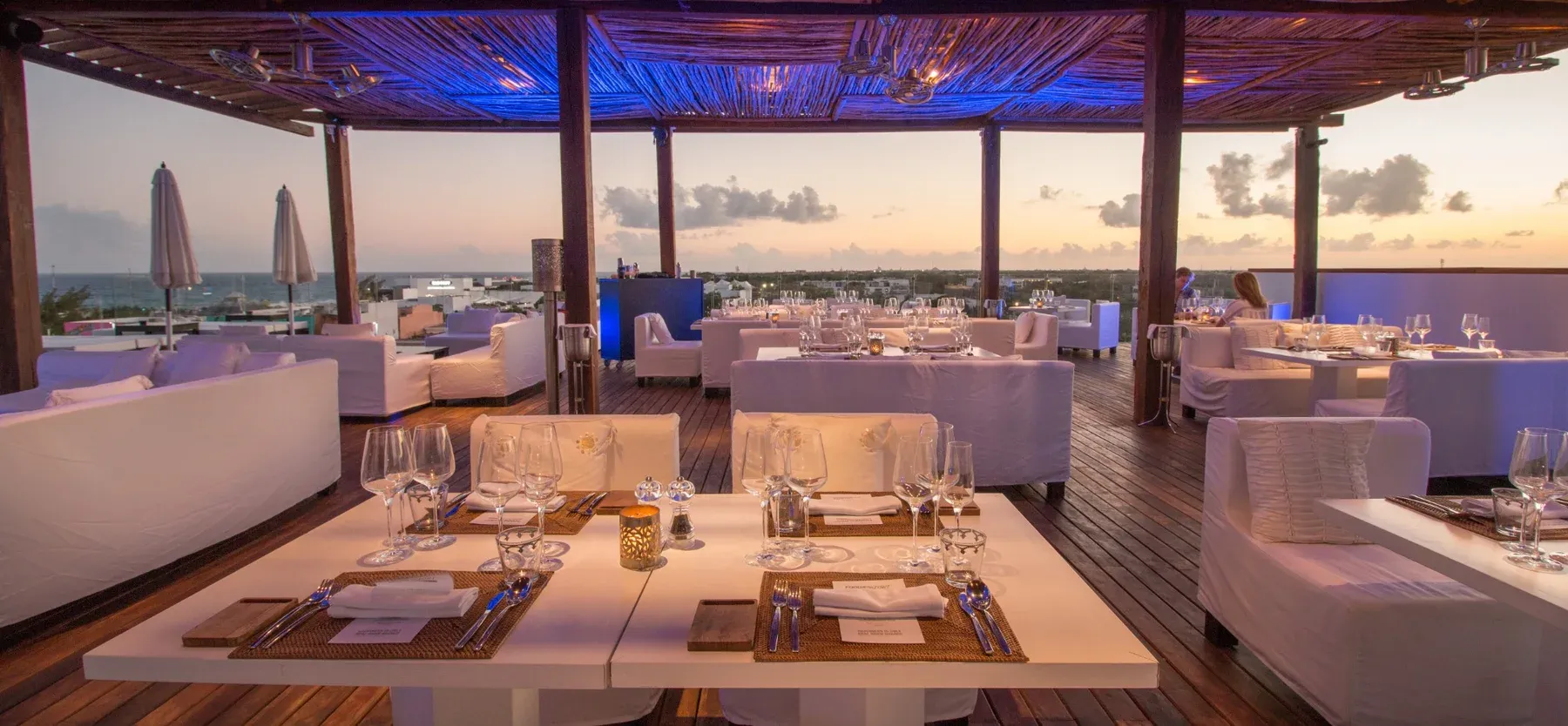 Rooftop dining with ocean views and elegant tables set for a romantic dinner at The Fives Corpo.