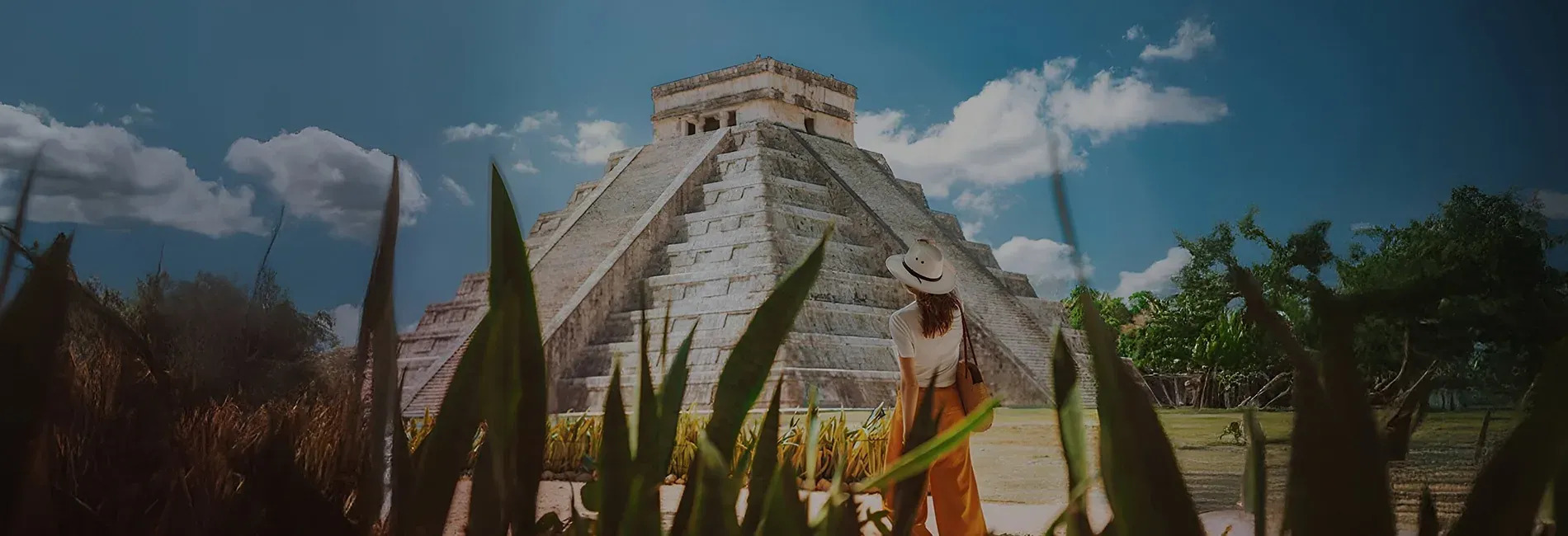 Woman admires El Castillo at Chichén Itzá, perfect for The Fives Corpo.