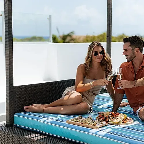 Couple enjoying champagne and food at The Fives Corpo.