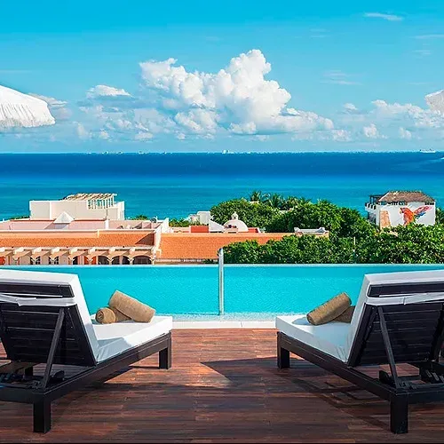 The Fives Corpo: Infinity pool overlooking the Caribbean Sea with lounge chairs.