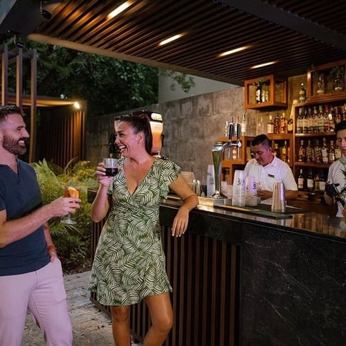 a man and a woman standing at a bar drinking