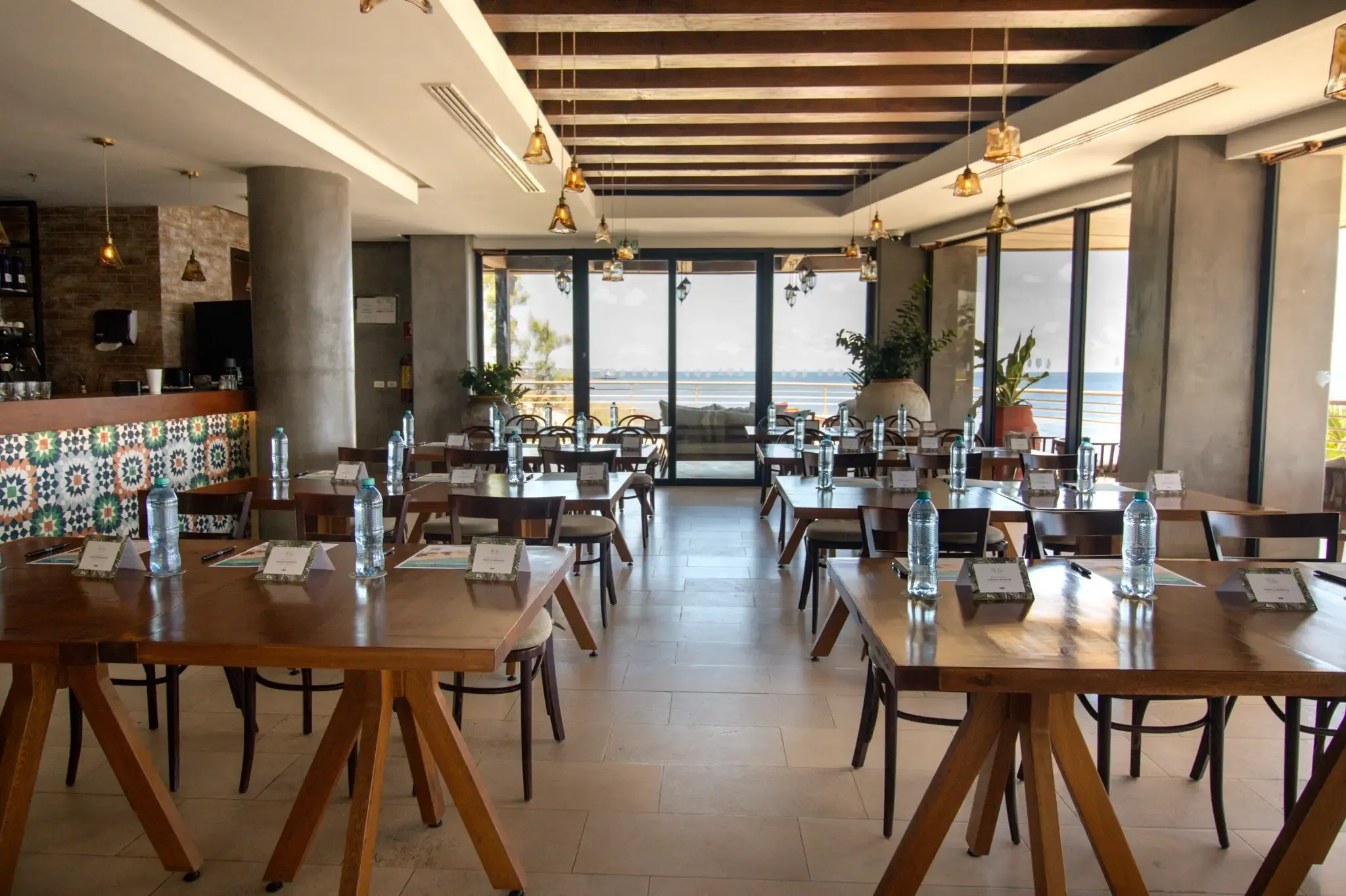 Mesas dispuestas para conferencias junto a la playa en hotel The Fives Corpo.