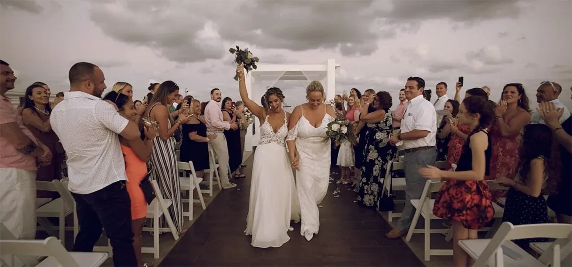 Brides celebrate their wedding at The Fives Corpus Christi as guests applaud.