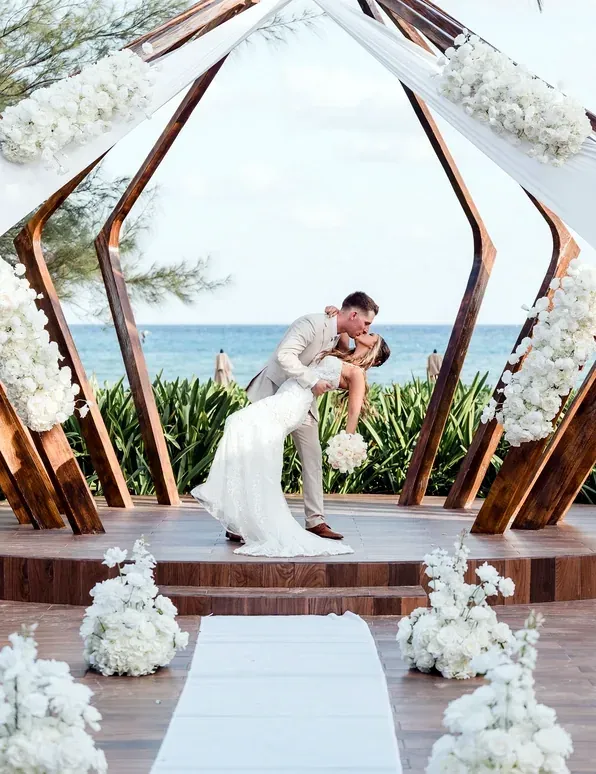 A wedding ceremony The Fives Corpo at a beachfront venue with a couple kissing.