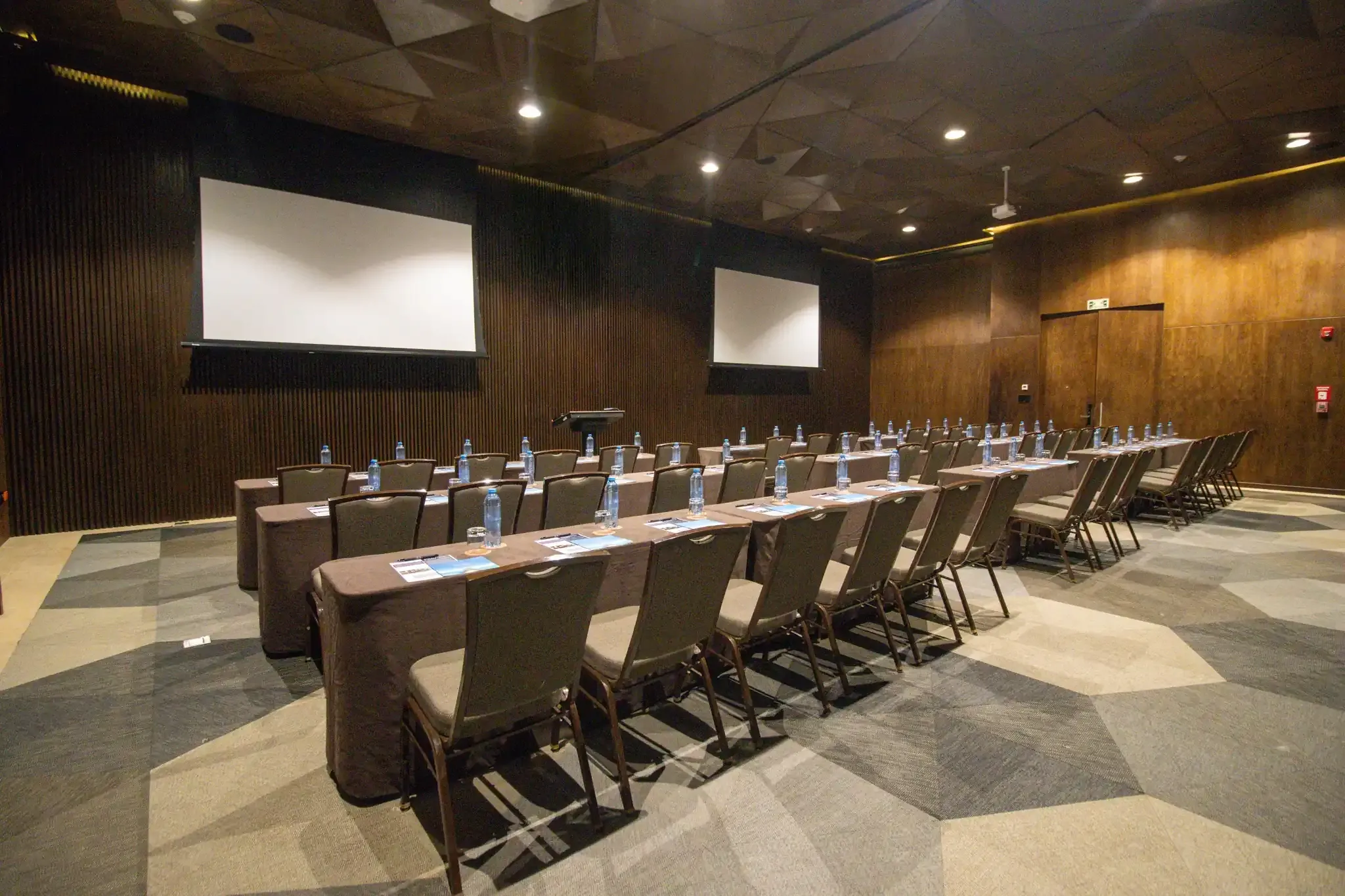 Conference room with tables, chairs, and projector screens, ideal for The Fives Corpo.