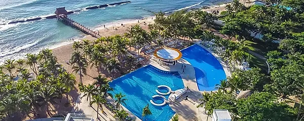 The Fives Corpo: Turquoise pool with palm trees and beach pier.