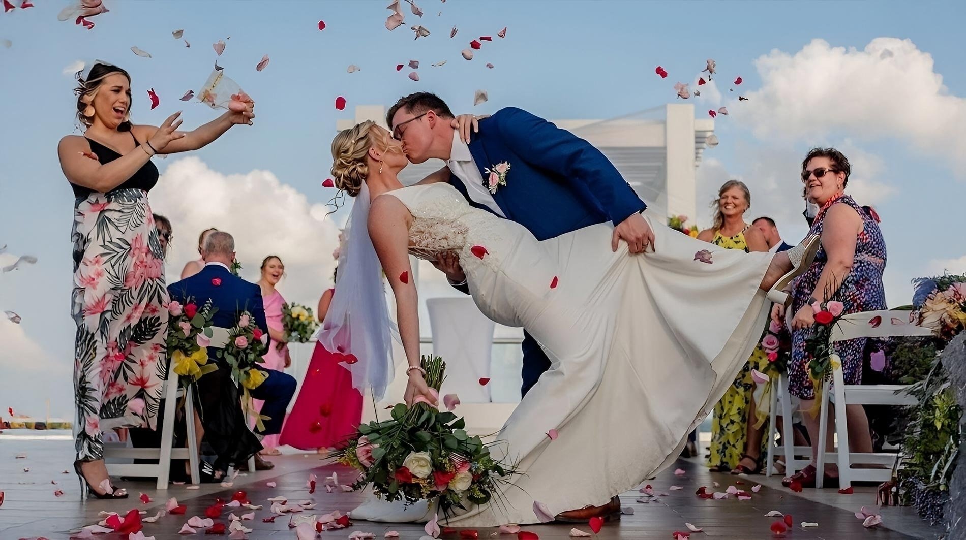a bride and groom kiss under a wooden arch