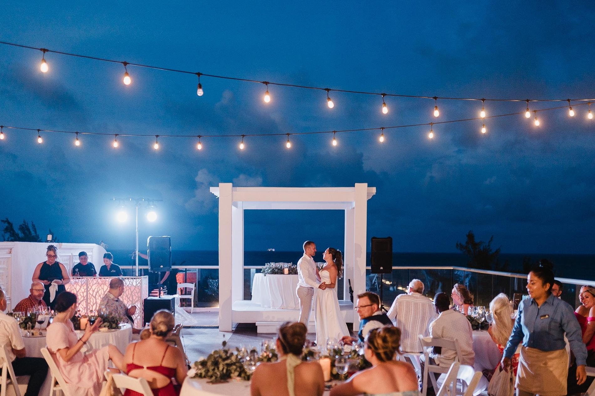 Celebración de boda rooftop con iluminación cálida y ambiente al aire libre