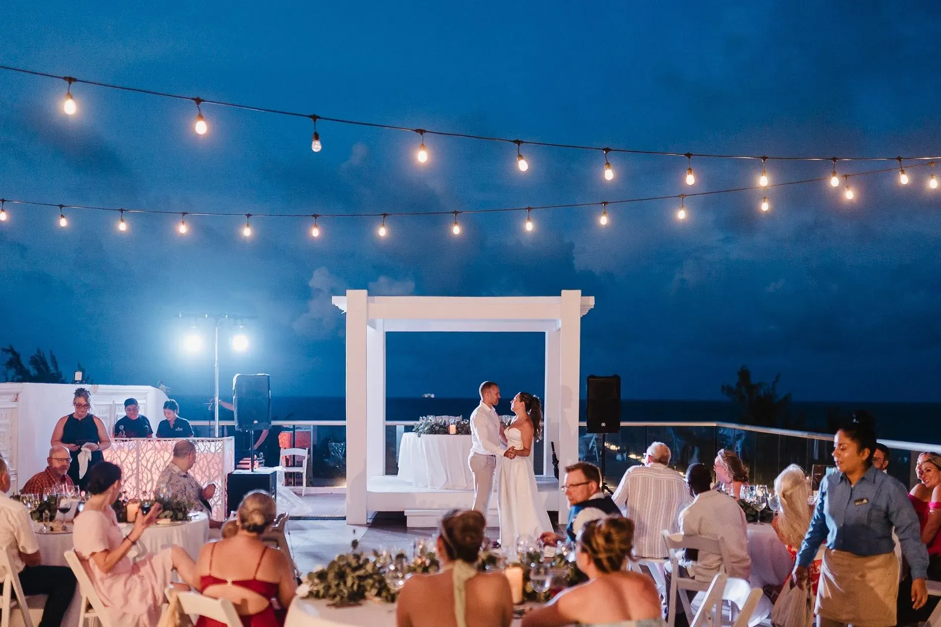 Celebración de boda rooftop con iluminación cálida y ambiente al aire libre