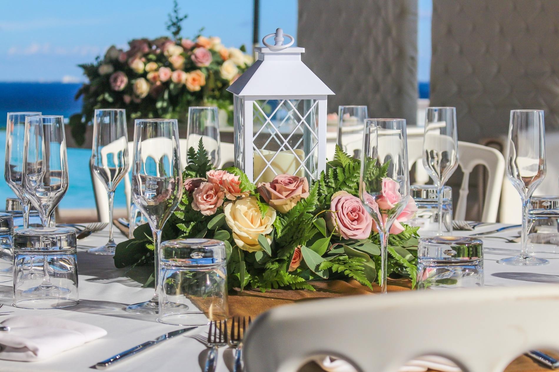 Detalles románticos de boda en terraza con flores tropicales y velas