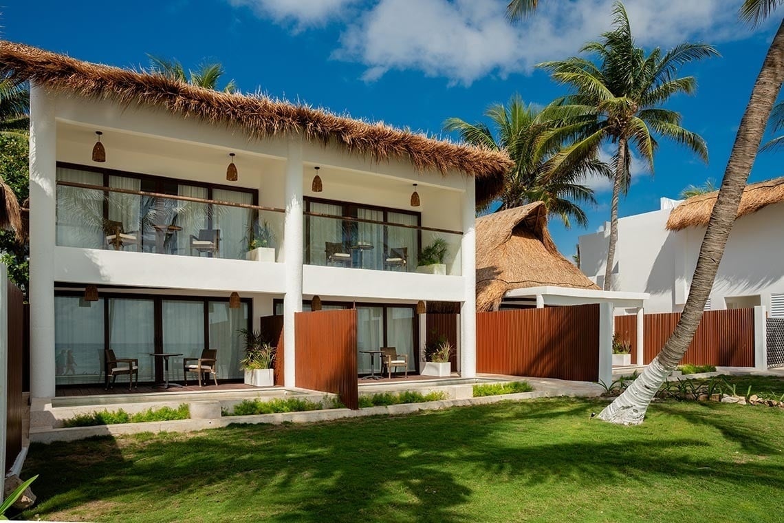 The Beachfront by The Fives: Oceanfront rooms with thatched roofs & palm trees.