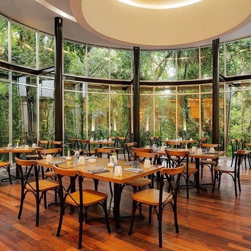 a restaurant with tables and chairs surrounded by windows