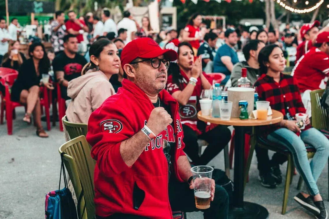 49ers fan at The Fives, cheering at an event.