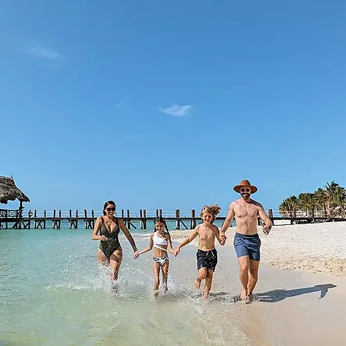 Family running into the ocean at The Fives Corpo, Riviera Maya