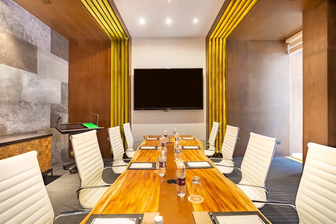 Modern boardroom at The Fives Corpo with wood table and white chairs.