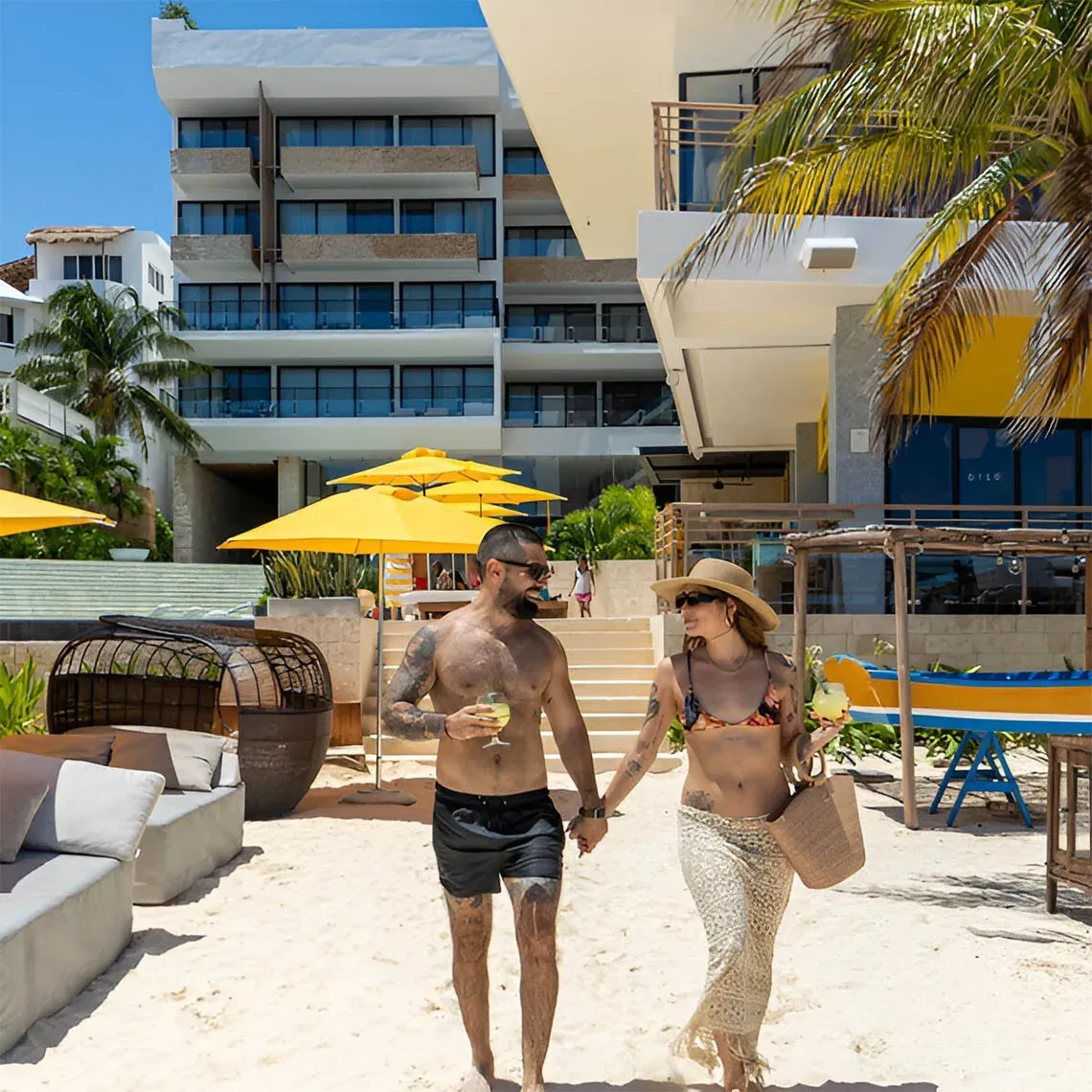 Pareja en The Fives Corpo disfrutando de la playa, piscina y vistas al mar.