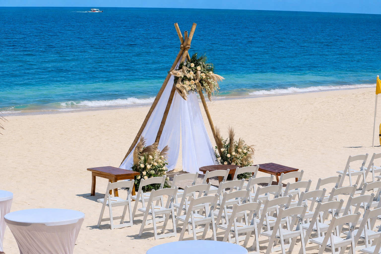 Beach wedding ceremony setup with flowers and ocean view