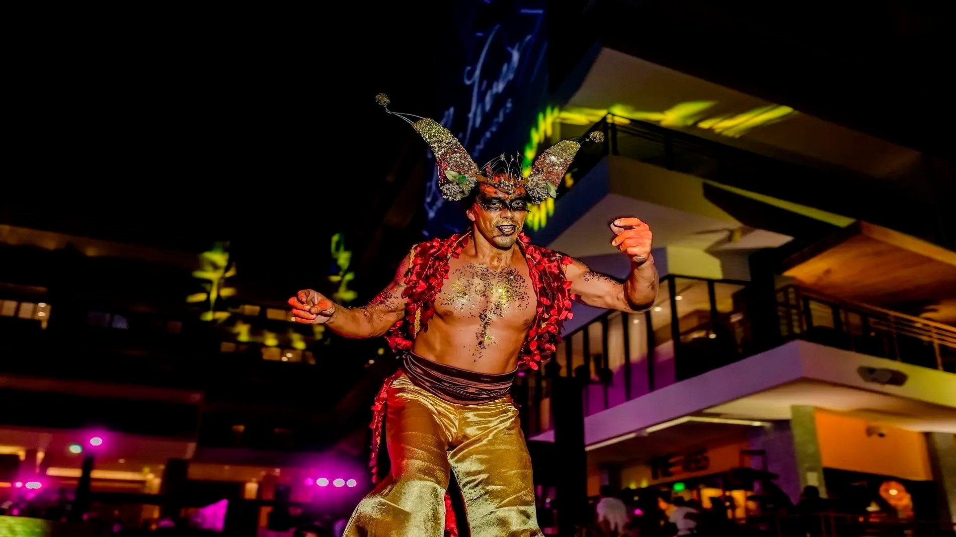 a man in a costume with horns stands in front of a sign that says fox