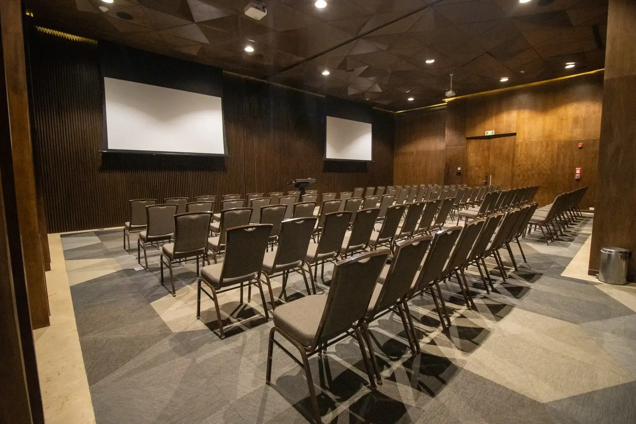 Conference room with rows of chairs and projectors, perfect for your next The Fives Corpo event.