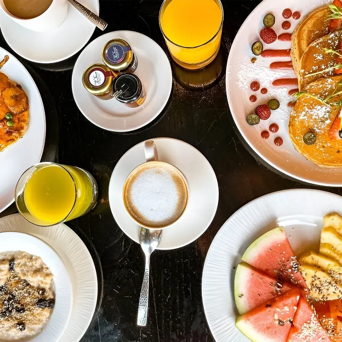 The Fives Corpo breakfast: coffee, pancakes, fruit, and more.