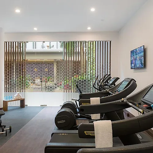 Modern gym at The Fives Corpo featuring treadmills and equipment.