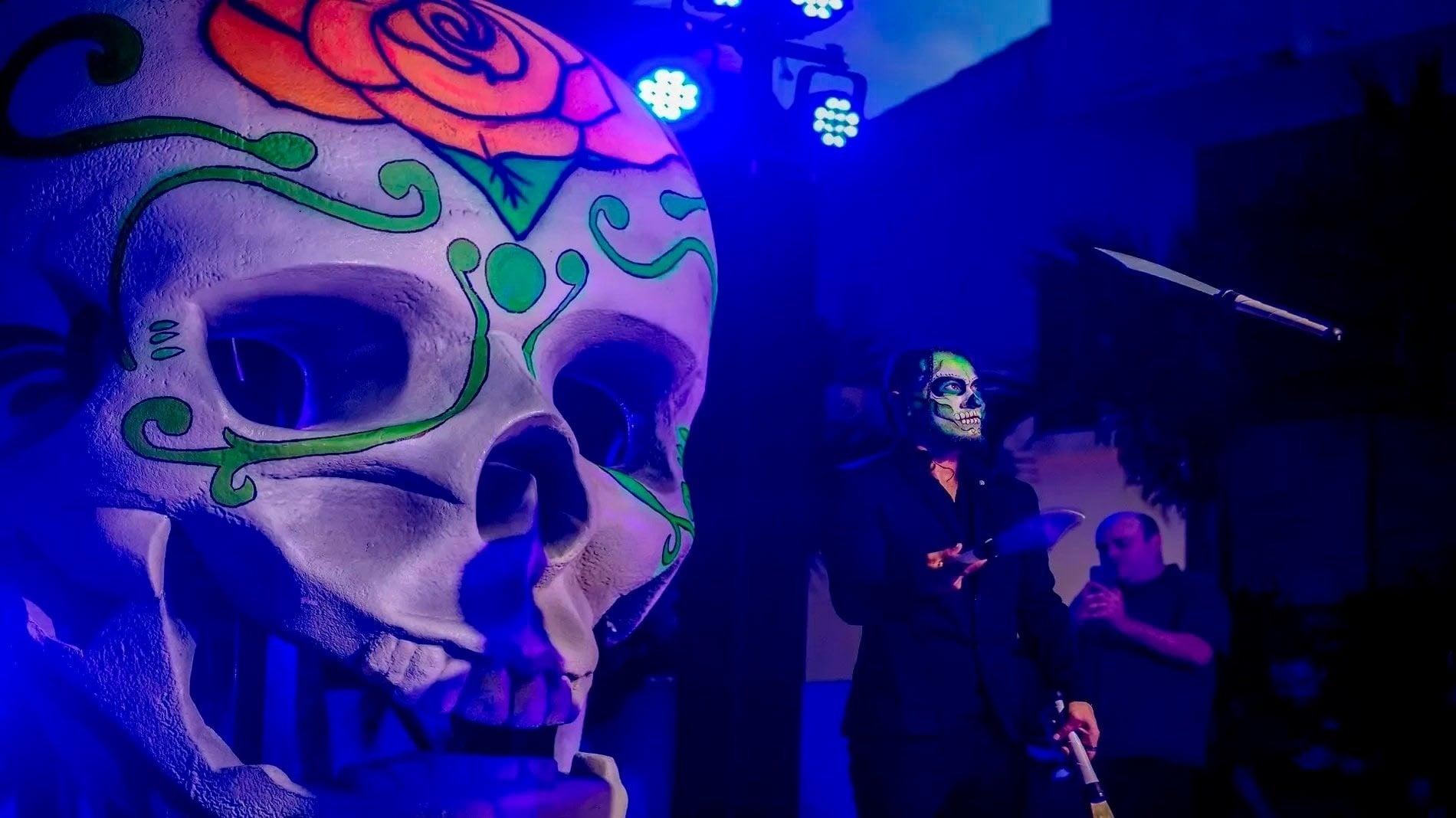 a man with a skull painted on his face stands in front of a microphone